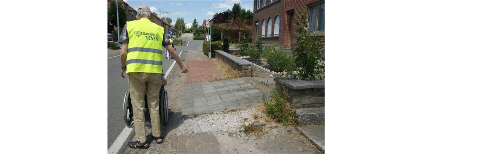 man met rolstoel op slechte voetpaden