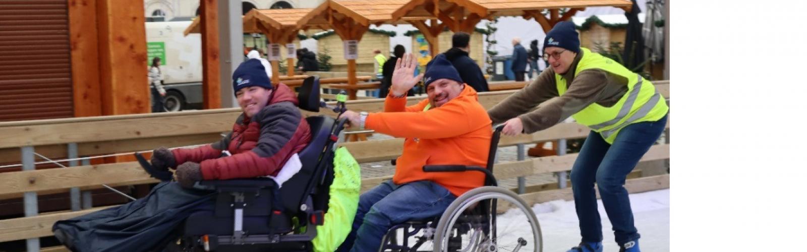 3 personen op de schaatsbaan waarbij 1 elektrische en 1 manuele rolstoel